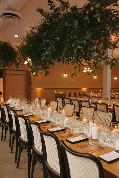 Candlelit head table with a baby's breath runner and black cane chairs